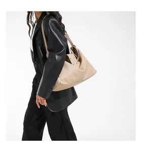 Detail van beige oversized shopper met zilveren studs en kiezellederen textuur