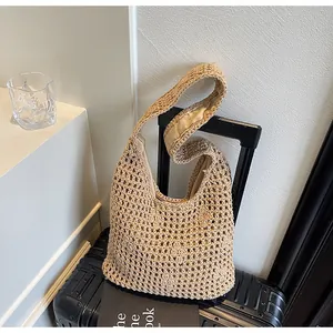 Hollow crochet knit shoulder bag in khaki on luggage, perfect for summer travel and beach
