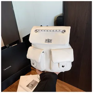 Detail of white glossy leather backpack with silver rotating locks and chain straps