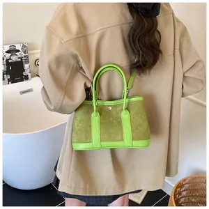 Detailed view of stylish green tote bag featuring mixed leather texture and metal rivets