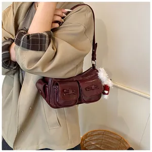 Detail of burgundy retro shoulder bag with bow pockets and plush charm accessory