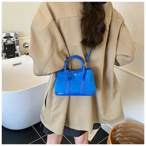 Blue mini tote bag shown on model with shoulder strap for a minimalist casual look