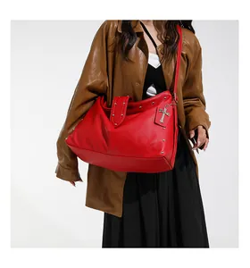 Detail van rode shopper met litchi-patroon, zilveren klinknagels en kruishanger