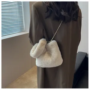 Détail d'un sac seau en fausse fourrure beige avec une bandoulière chaîne dorée