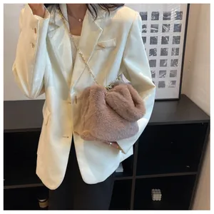 Gros plan du sac bandoulière en fausse fourrure avec chaîne dorée pour look automne-hiver