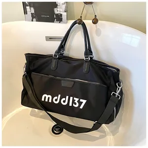 Detail of black large capacity travel bag with multiple pockets and shoulder strap