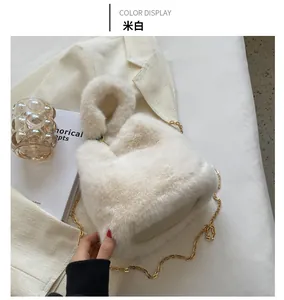 Gros plan d'un sac à main beige en fausse fourrure avec bandoulière chaîne dorée élégante