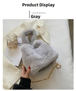 Détail du sac cabas en fausse fourrure grise avec bandoulière dorée sur un costume blanc