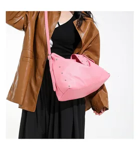 Detail van roze lederen draagtas met zilveren studs en kiezeltextuur in hobo-stijl