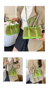 Detail view of green suede contrast tote bag with leather handles and long shoulder strap