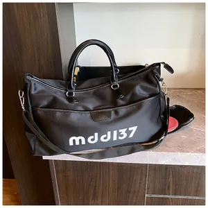 Detail view of large black waterproof travel bag with leather handles and side zip pocket