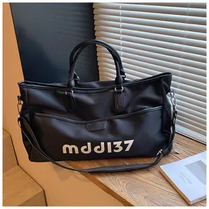 Close-up of black high-density Oxford travel bag with white mddJ37 letter print