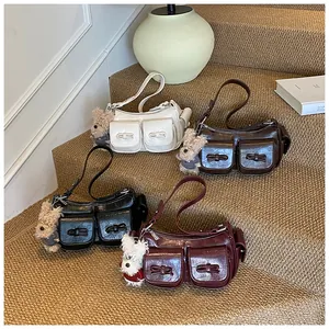 Detail of four retro shoulder bags in oil wax leather with bow relief and plush charms