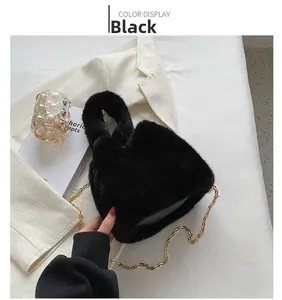 Détail d'un sac en fausse fourrure noire avec bandoulière en chaîne dorée et texture peluche
