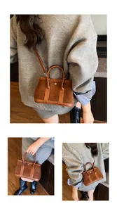 Detail of vintage brown suede tote bag featuring silver rivet closure and leather handles
