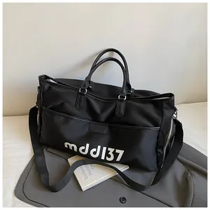 Detail of black oxford fabric travel bag with silver zipper and sturdy carry handles