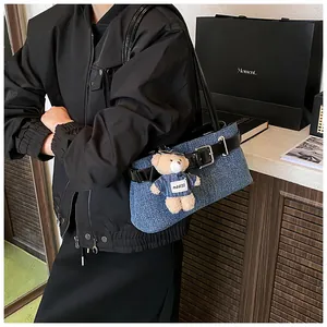 Detail der blauen Denim-Umhängetasche mit schwarzen Lederriemen und silbernen Schnallen