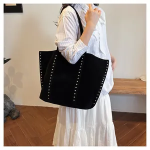 Détail du sac cabas en nylon noir avec rivets métalliques porté par un mannequin pour le quotidien