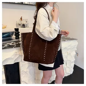 Détail du grand sac cabas en daim marron avec rivets argentés et longues bandoulières