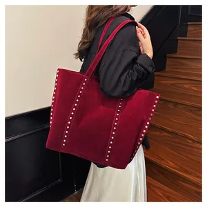 Vue détaillée du sac cabas en daim bordeaux avec décorations de rivets métalliques