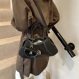 Borsa a mano chic in pelle lucida nera con cuciture a contrasto e mini pochette charm