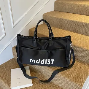 Large black Oxford cloth travel bag with leather handles and white letter print