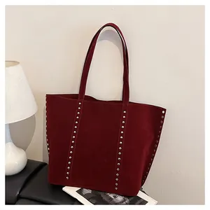 Détail du sac cabas bordeaux montrant la texture daim doux et les rivets argentés