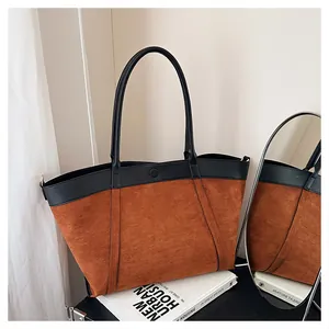 Detalle del bolso tote grande de ante sintético con costuras en contraste y cierre imán