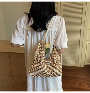 Detail of bohemian crochet tote bag featuring hollow geometric patterns and tassel edges