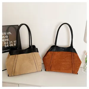 Detalle de bolsos tote de ante en beige y caramelo con asas de cuero negro y textura