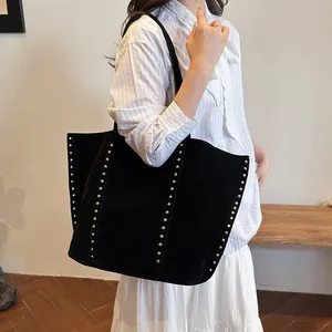 Sac fourre-tout noir en nylon avec rivets argentés et grande capacité porté à l'épaule
