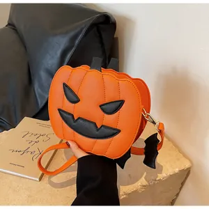 Detail of orange pumpkin bag with Saffiano texture and black bat pendant accessory