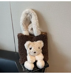 Detail of plush teddy bear charm on brown faux shearling tote bag over a book