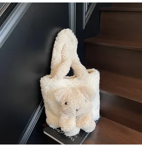 Detailed close-up of cream faux shearling tote bag with a 3D teddy bear plush ornament