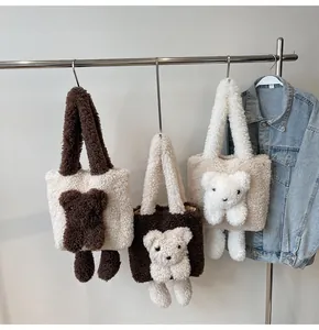 Detailed view of plush teddy bear tote bags in multiple colors hanging on a metal rack