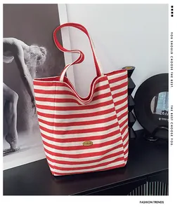 Dettaglio della borsa tote in tela a righe rosse e bianche con etichetta fatta a mano