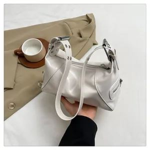 Detail of white glossy shoulder bag featuring silver hardware and side zipper pockets