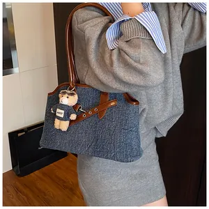 Modische Denim-Einkaufstasche mit braunen Ledergriffen und süßem Bärenanhänger-Detail