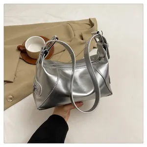Detail of silver metallic shoulder bag with smooth texture and side zipper accent