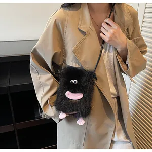 Détail du sac à bandoulière monstre en peluche noire avec lèvres roses et yeux drôles