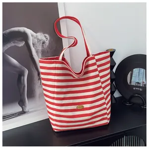 Dettaglio della borsa tote in tela a righe rosse e bianche con etichetta fatta a mano