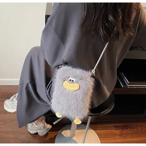 Détail d'un sac à bandoulière en peluche grise avec une bouche de dessin animé rigolote