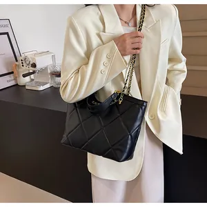 Close-up of black quilted tote bag with diamond stitching and elegant chain strap detail