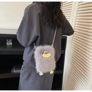 Vue détaillée du sac bandoulière en peluche grise avec un design amusant de bouche cartoon