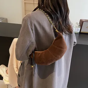 Retro dark brown suede croissant bag with gold chain strap on model in gray blazer