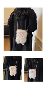 Détail du sac monstre en peluche avec lèvres roses et pieds mignons sur un blazer