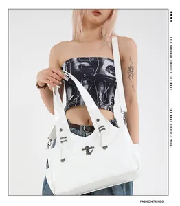 Dettaglio della borsa tote bianca lucida con ornamento in argento e cuciture rifinite