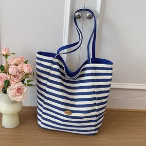 Borsa tote in tela a righe blu e bianche con placca in metallo dorato fatta a mano