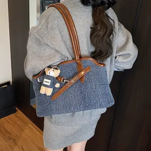 Denim-Tragetasche mit braunem Lederbesatz und Bären-Schlüsselanhänger für den Alltag