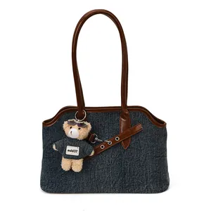 Vintage-Denim-Einkaufstasche mit braunen Ledergriffen und einem Plüschbär-Anhänger
